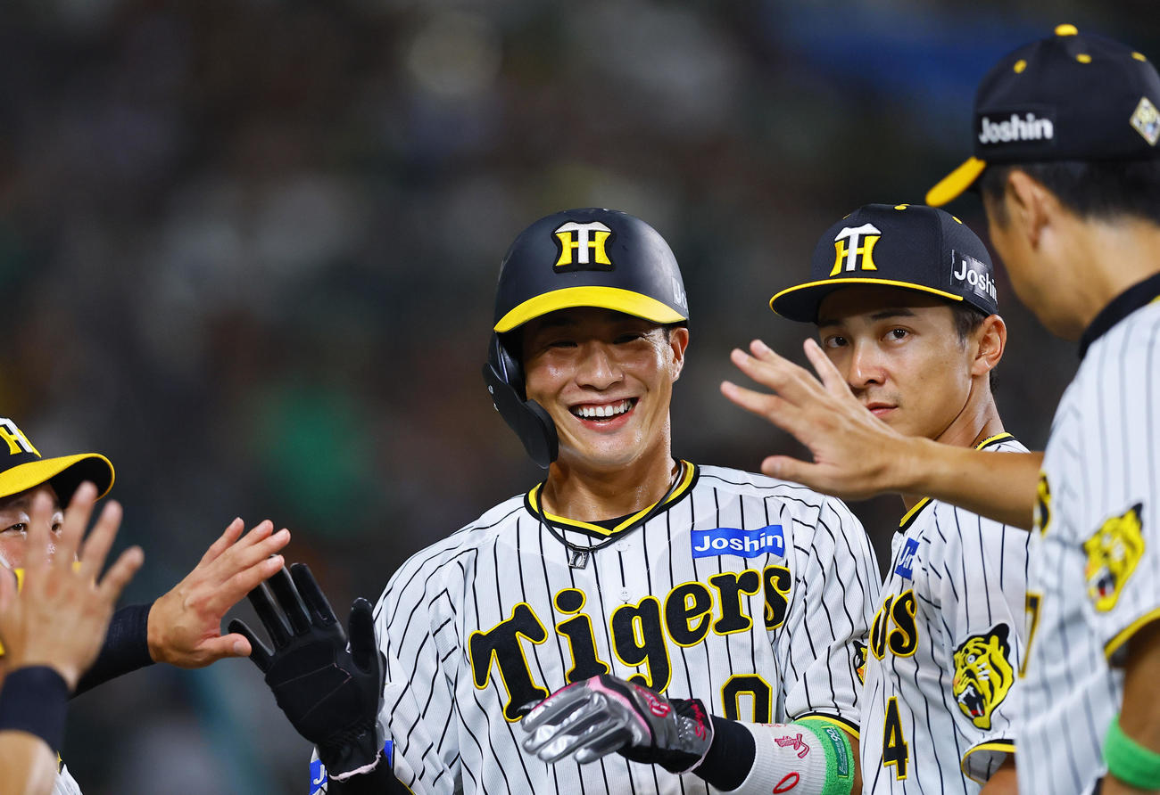 阪神対巨人　5回に2点適時三塁打を放ち笑顔でナインとタッチを交わす阪神木浪（撮影・藤尾明華）