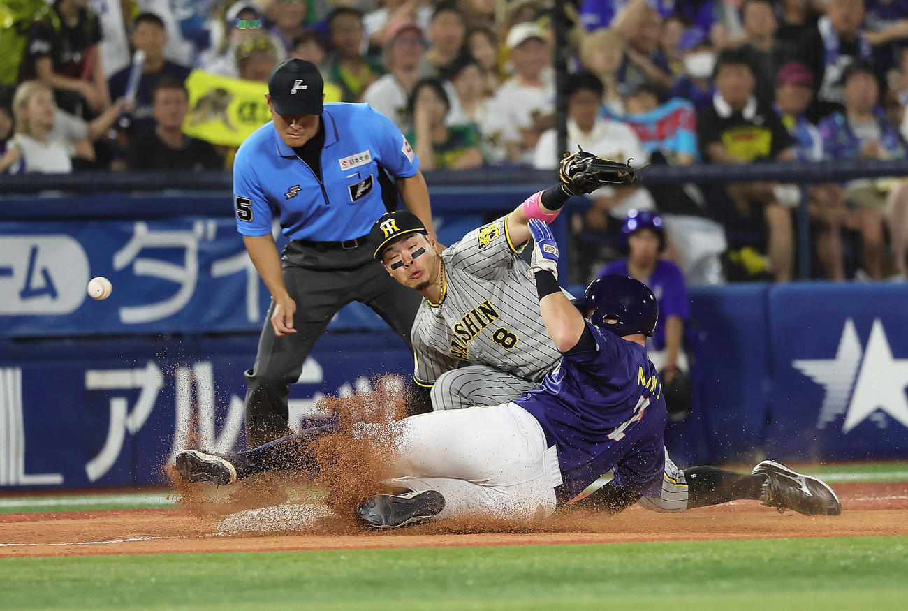 DeNA対阪神　7回裏DeNA2死一、二塁、佐野の中前打の送球を捕球できず一塁走者牧（手前）の生還を許す三塁手佐藤輝。記録は中堅手近本の悪送球（撮影・足立雅史）
