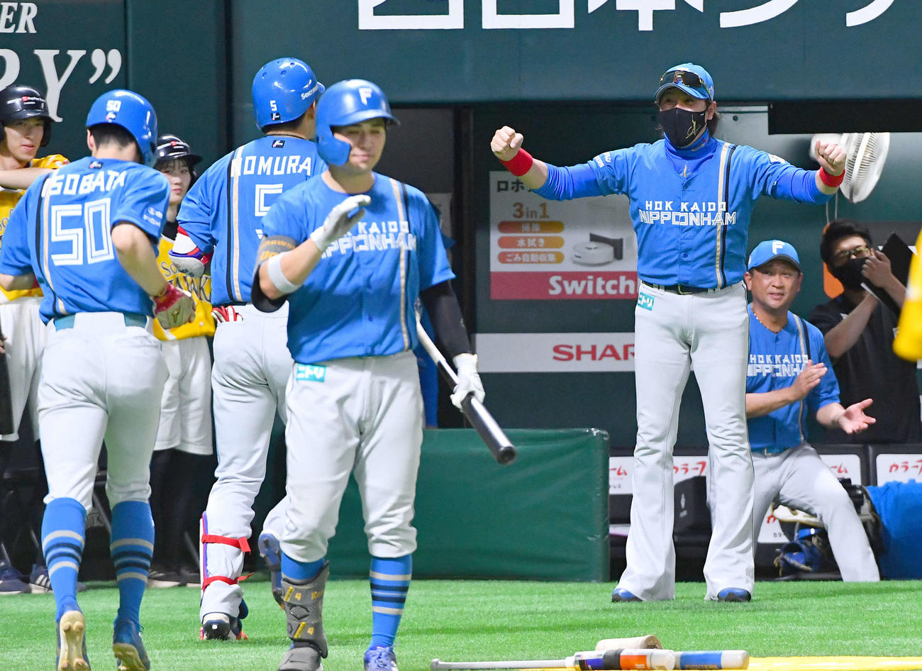 ソフトバンク対日本ハム　7回表日本ハム2死一塁、逆転の中越え2点本塁打を放った野村（左から2人目）をガッツポーズで迎える新庄監督（撮影・岩下翔太）