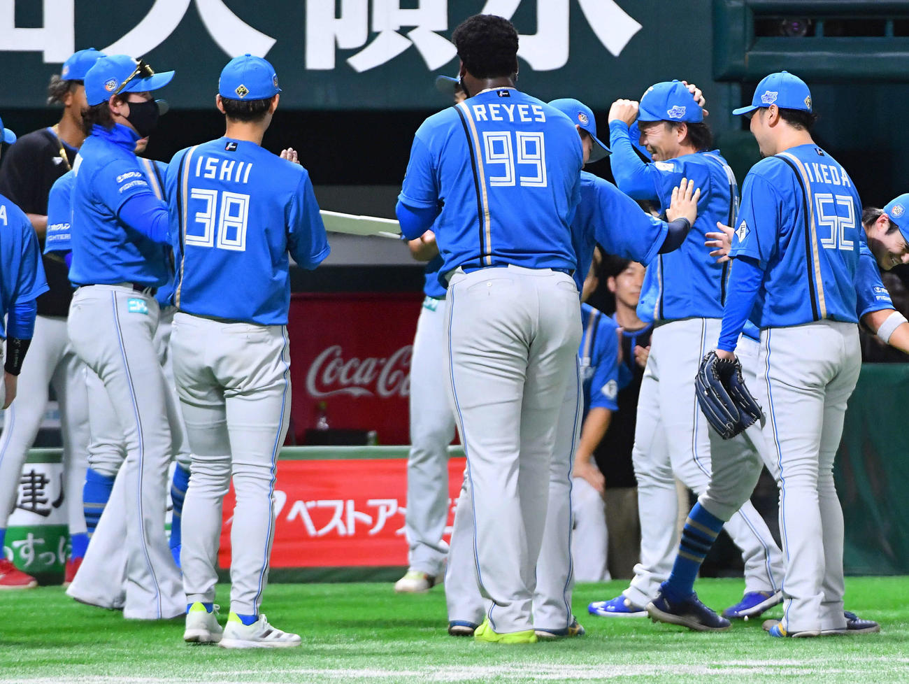ソフトバンク対日本ハム　8回裏終了後、通算400ホールドを達成した宮西（右から2人目）は、記念ボードを持ってきた新庄監督（左）に笑顔を見せる（撮影・岩下翔太）