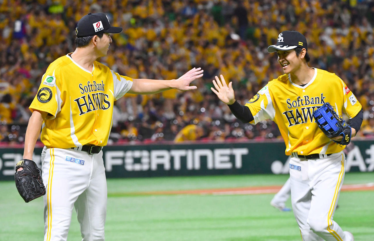 ソフトバンク対日本ハム　2回表日本ハム2死、石井の左飛を好捕した柳町（右）とタッチを交わす大関（撮影・岩下翔太）