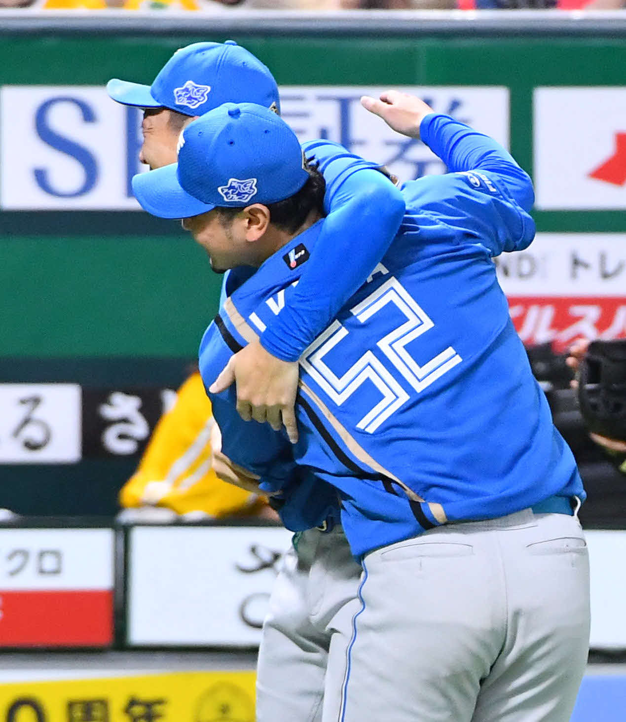 ソフトバンク対日本ハム　8回裏終了後、通算400ホールドを達成した宮西（左）は、3番手でピンチをしのいた池田に笑顔で抱きつく（撮影・岩下翔太）