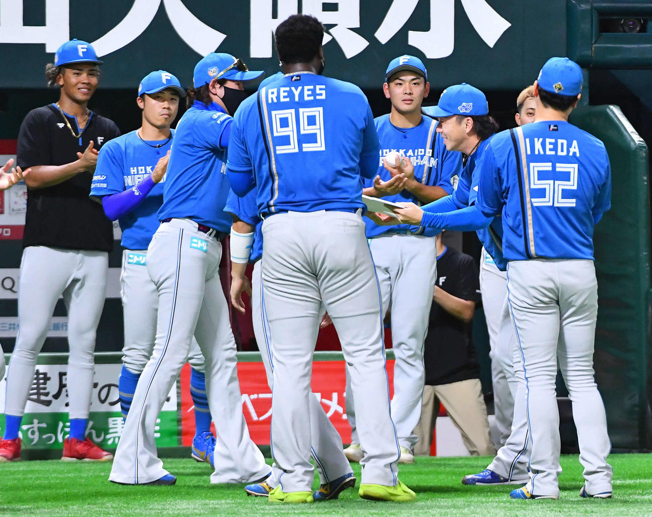 ソフトバンク対日本ハム　8回裏終了後、通算400ホールドを達成した宮西（右から2人目）は、新庄監督（左から3人目）から記念ボードを受け取る（撮影・岩下翔太）