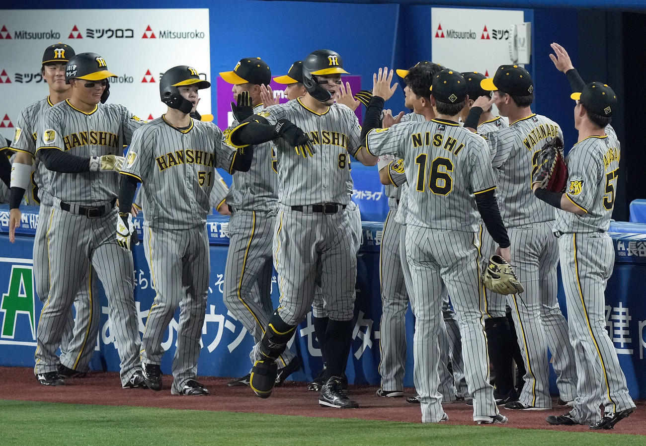 DeNA対阪神　5回表阪神1死一、二塁、中越えに3点本塁打を放ちナインの出迎えを受ける佐藤輝（撮影・たえ見朱実）