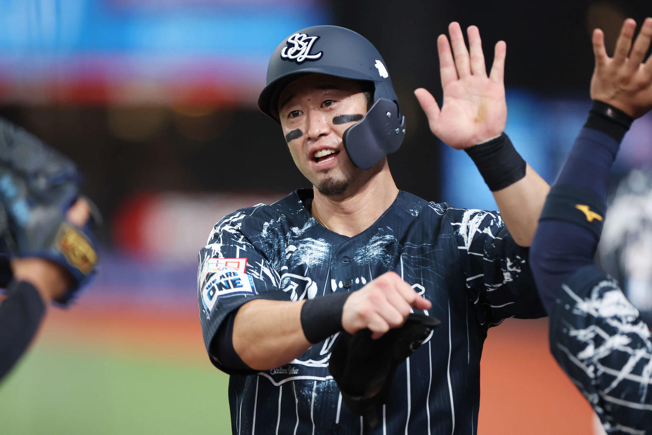 西武対楽天　1回裏西武2死二塁、ガルシアの中適時二塁打で生還した外崎はチームメートとタッチを交わす（撮影・宮地輝）