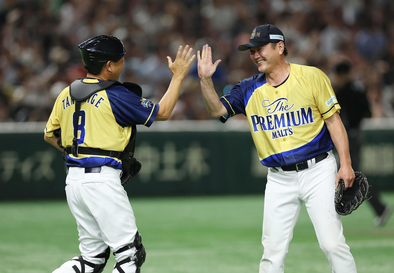ザ・プレミアム・モルツ球団対ドリーム・ヒーローズ　ドリーム・ヒーローズに勝利しタッチを交わす谷繁氏（左）と岩瀬氏（撮影・前田充）