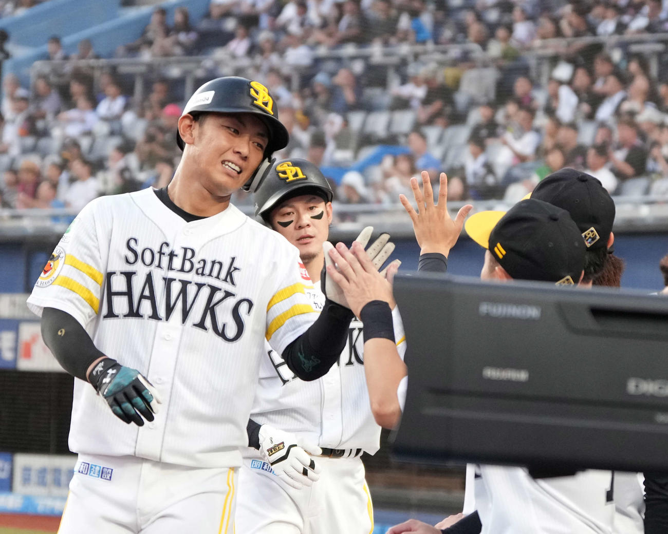 ロッテ対ソフトバンク　1回表ソフトバンク無死二、三塁、栗原の先制2点右適時二塁打で生還した、（左から）今宮、牧原大はベンチのナインの祝福を受ける（撮影・小沢裕）