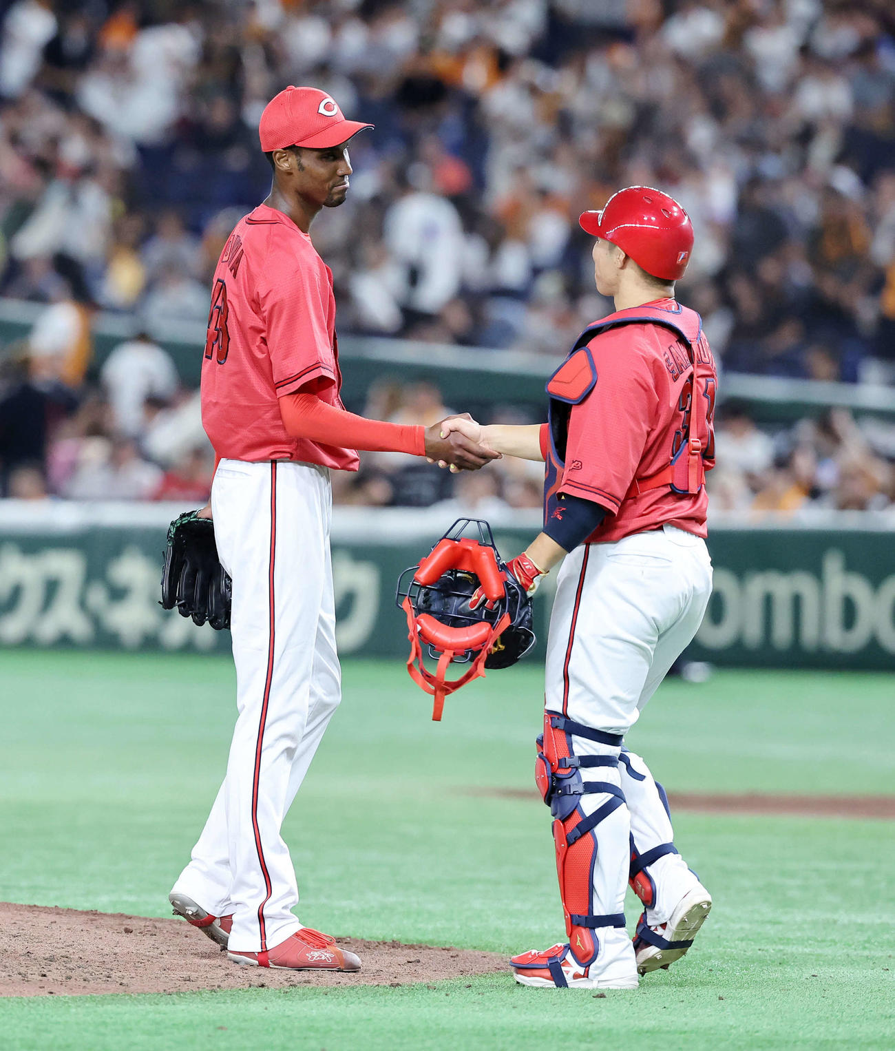 巨人対広島　初完封勝利した広島アドゥワ（左）は坂倉と握手（撮影・鈴木正人）