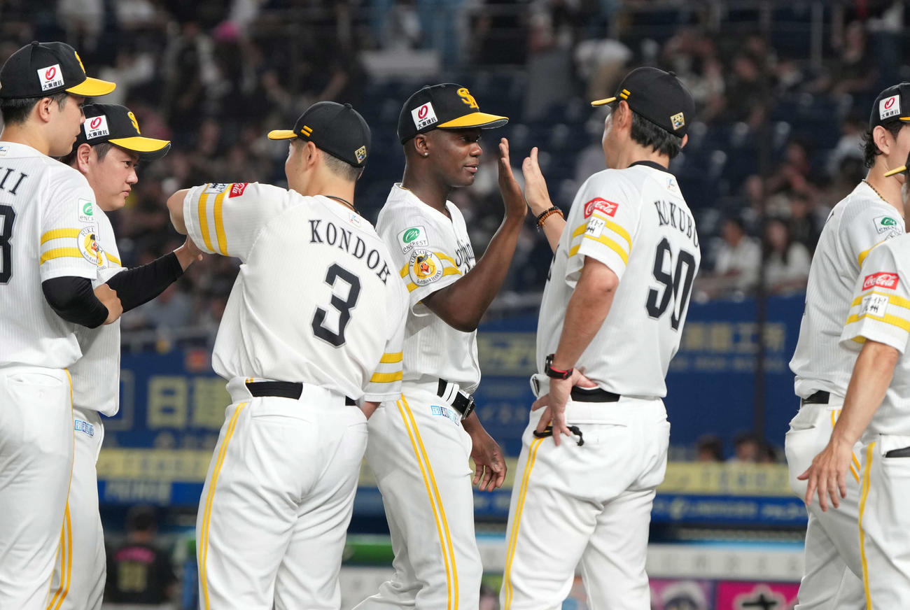 ロッテ対ソフトバンク　今季8勝目を挙げたソフトバンク先発のモイネロ（中央）は小久保監督の祝福を受ける（撮影・小沢裕）