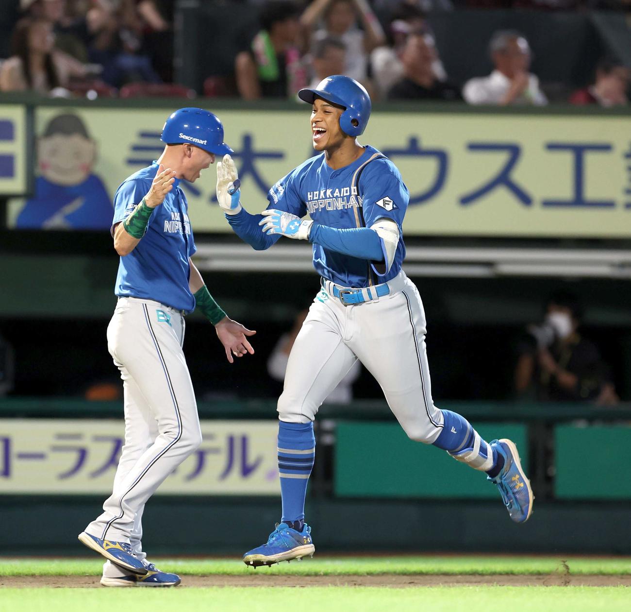 楽天対日本ハム　10回表日本ハム2死満塁、右越え満塁本塁打を放ち笑顔で森本コーチとタッチする万波（撮影・黒川智章）