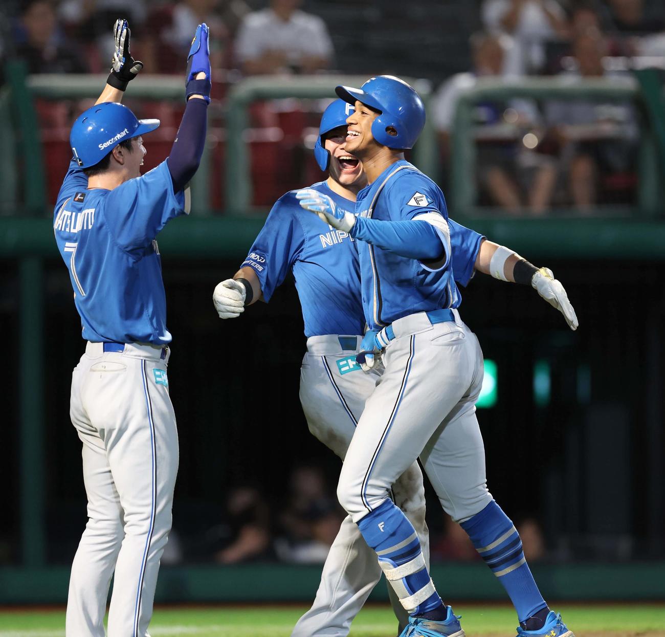 楽天対日本ハム　10回表日本ハム2死満塁、右越え満塁本塁打を放ち笑顔で生還する万波（右）（撮影・黒川智章）
