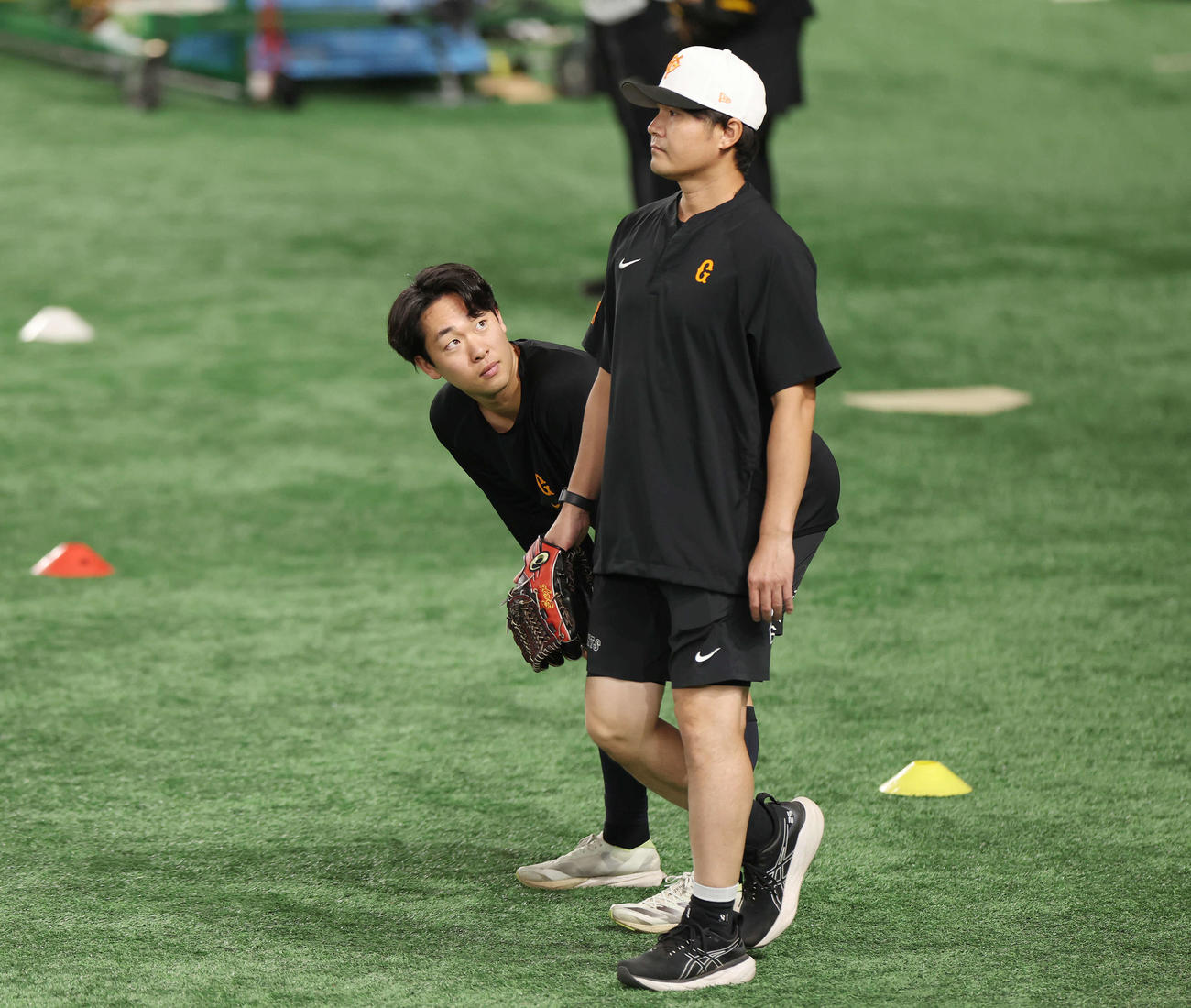 巨人対広島　試合前、タッチしてきた巨人杉内投手チーフコーチ（右）を見つめる山崎伊（撮影・宮地輝）