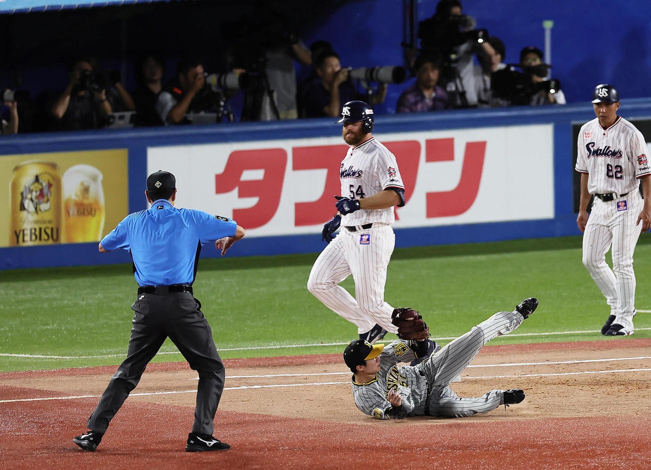 ヤクルト対阪神　2回裏ヤクルト1死一、二塁、三塁手佐藤輝の送球がそれ出塁するサイスニード（後方）。二塁手中野（撮影・足立雅史）
