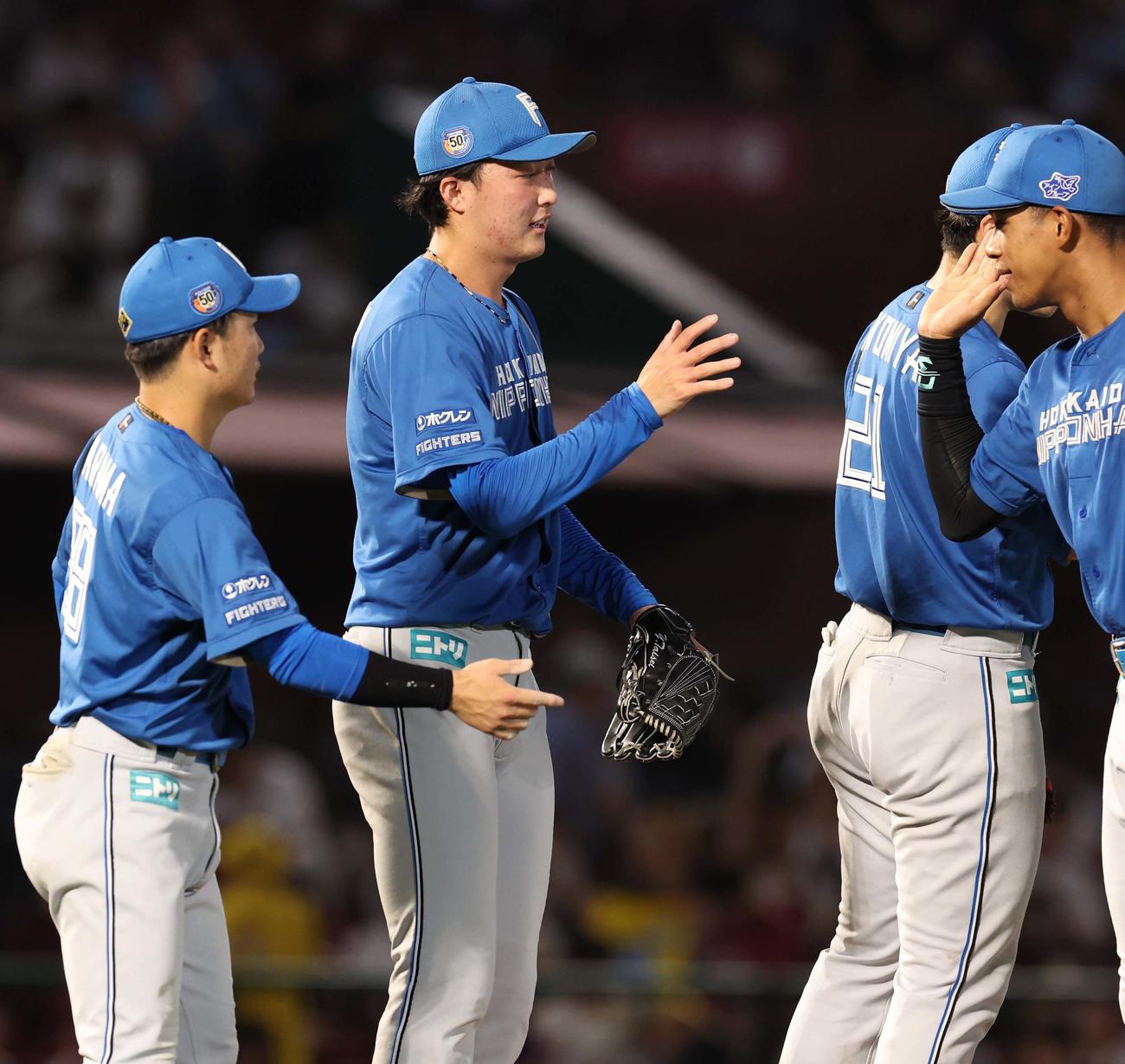 楽天対日本ハム　9回に登板しプロ初セーブを挙げた柳川（左から2人目）はナインとタッチする（撮影・黒川智章）