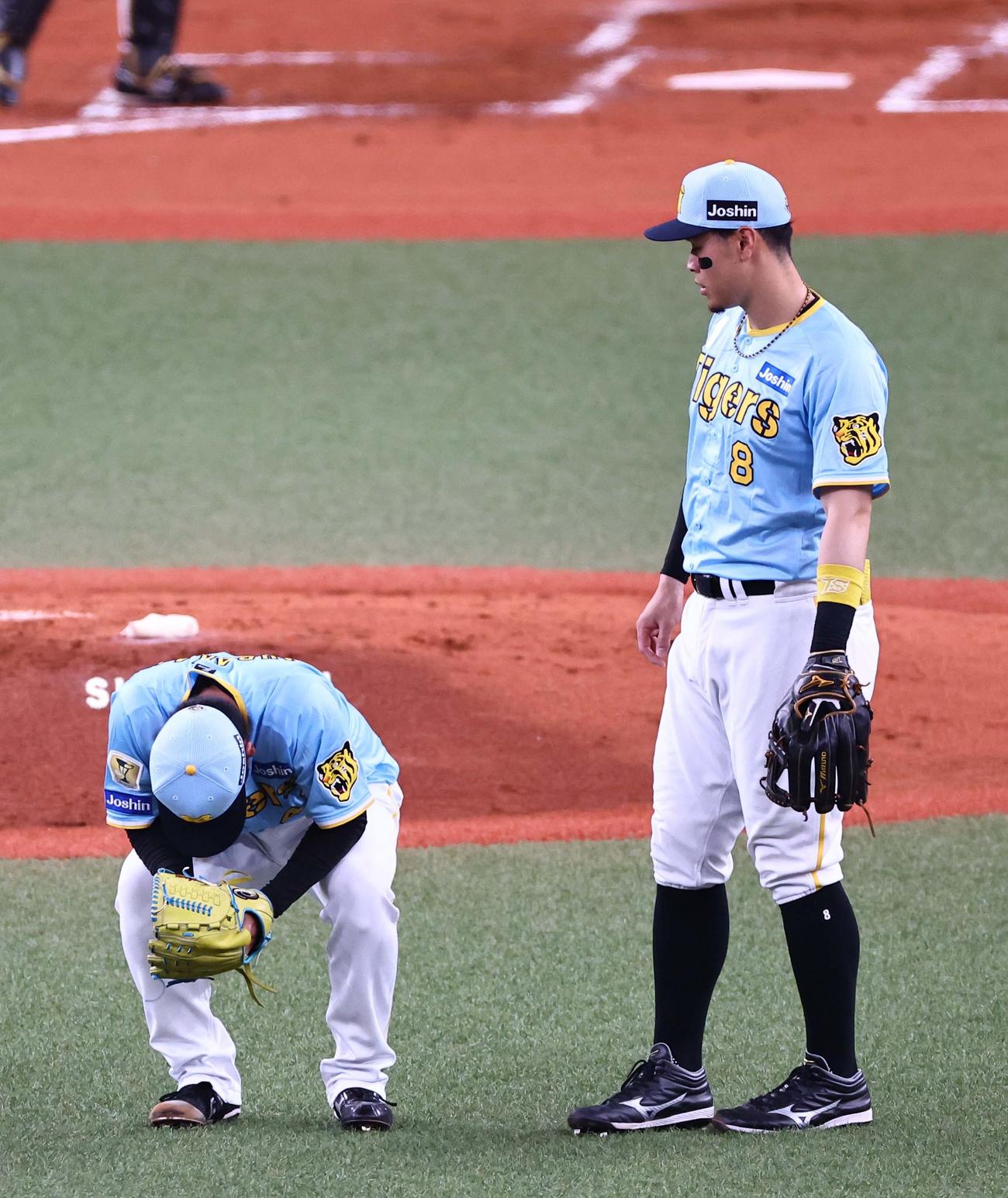 阪神対広島　3回表広島2死三塁、村上は坂倉に適時内野安打を浴び座り込んで悔しがる。右は佐藤輝（撮影・上田博志）