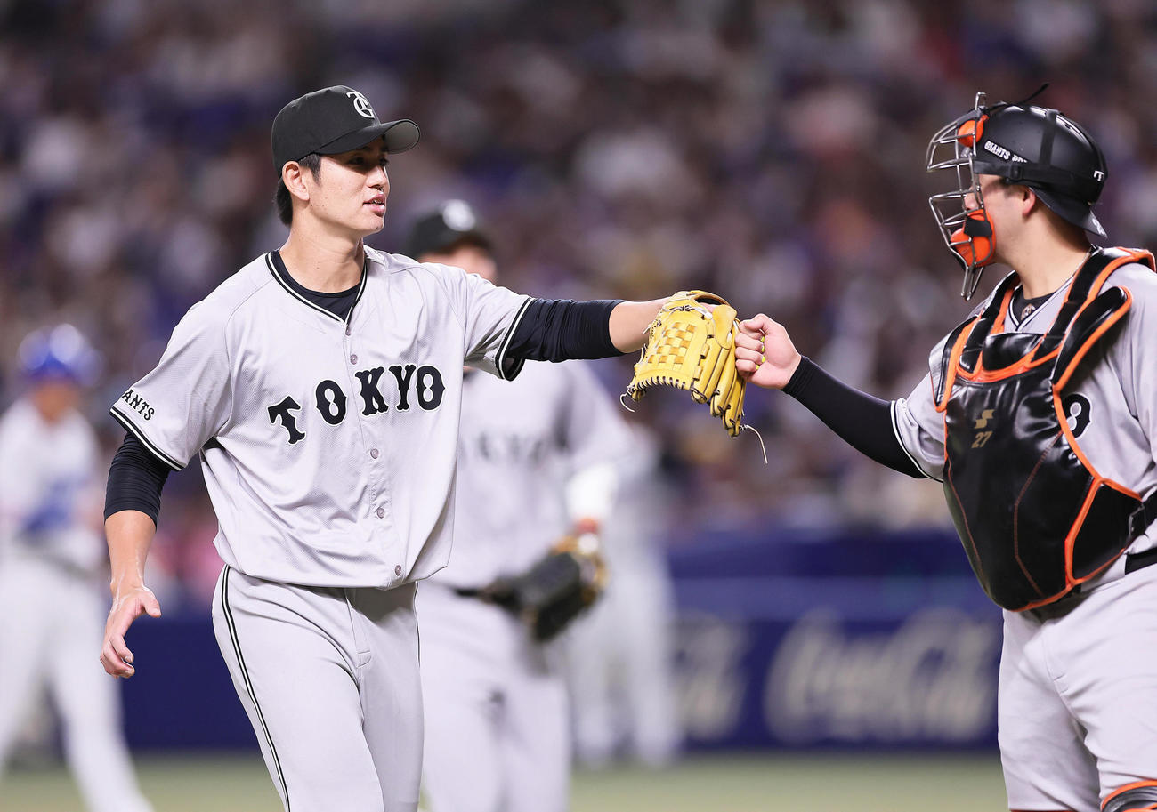 中日対巨人　2回裏中日2死二塁、カリステを三ゴロに仕留めタッチを交わす高橋礼（左）と岸田（撮影・足立雅史）