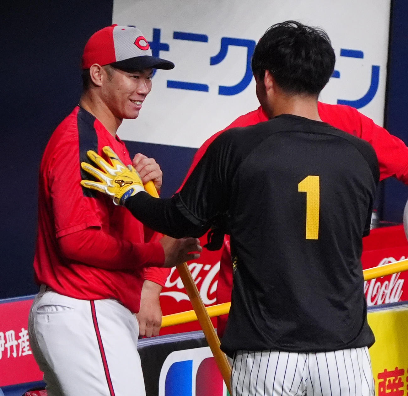 阪神対広島　前日9日の試合で5安打の広島坂倉（左）をさわりあやかろうとする阪神森下（撮影・清水貴仁）