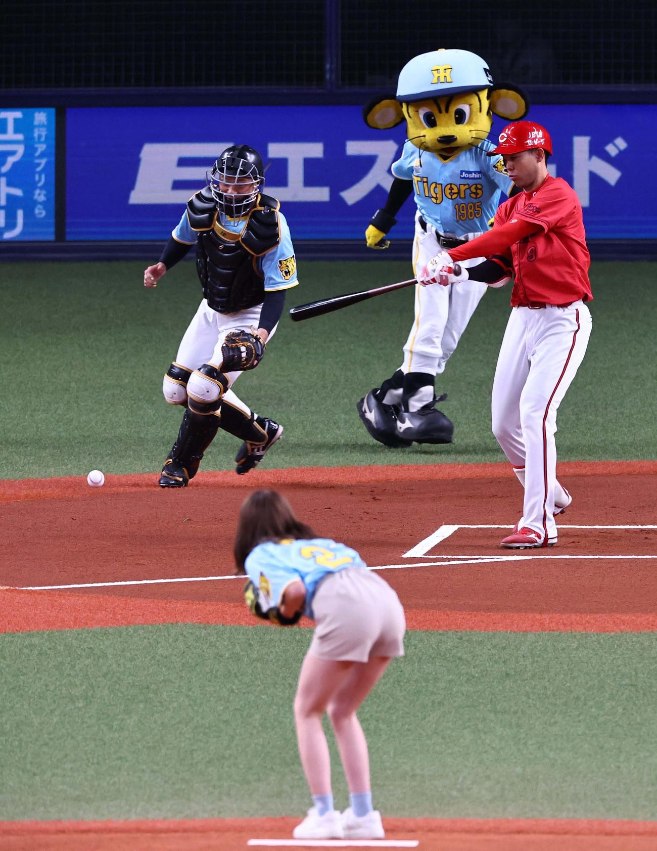 阪神対広島　始球式を務めたNMB48平山真衣の暴投に逆を向いて空振りする秋山（撮影・上田博志）