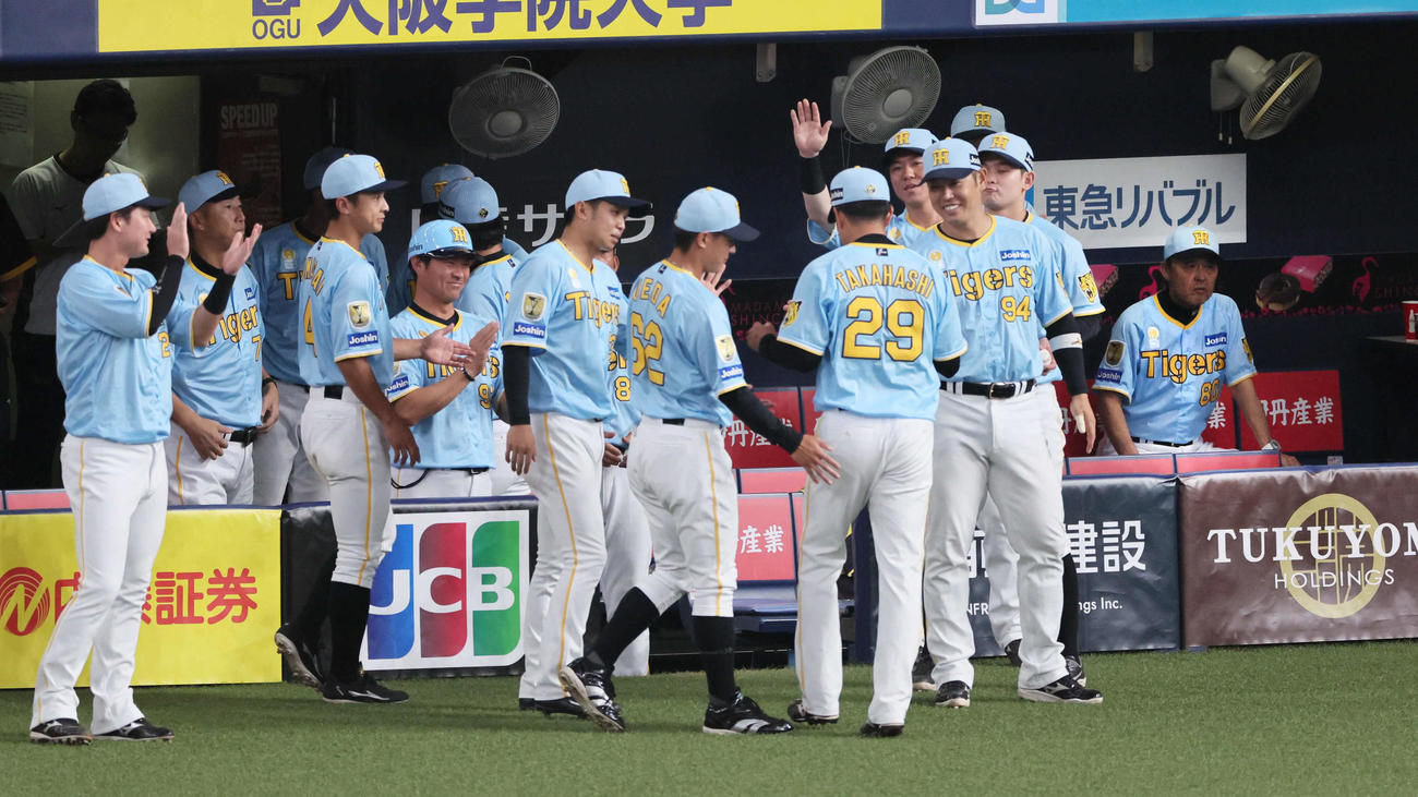 阪神対広島　1回表を3者三振に仕留めた高橋を迎える阪神ナイン。右端は岡田監督（撮影・宮崎幸一）