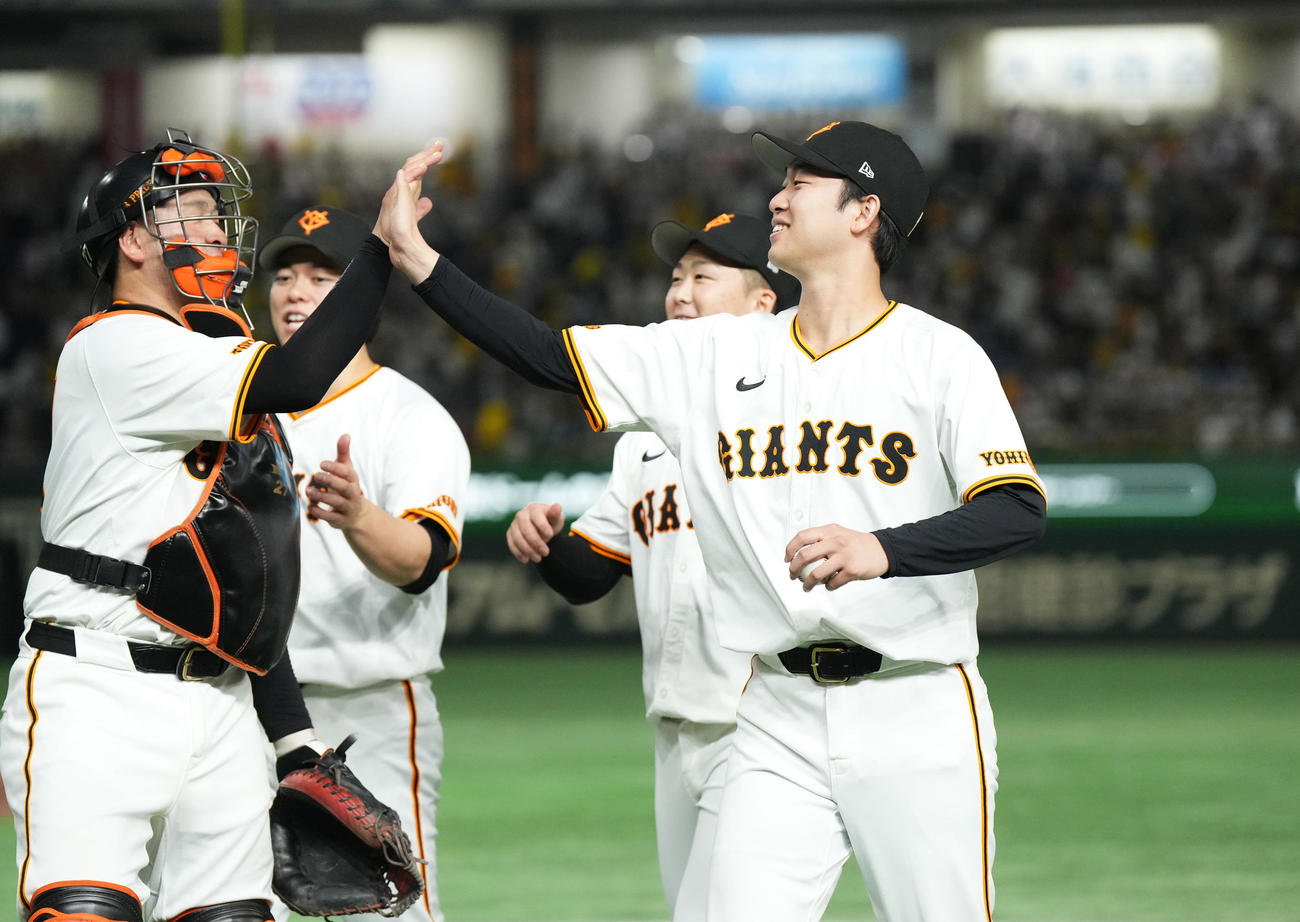 巨人対阪神　阪神に勝利し、ウイニングボールを手に捕手岸田（左）とタッチをする巨人山崎伊（右）（撮影・菅敏）