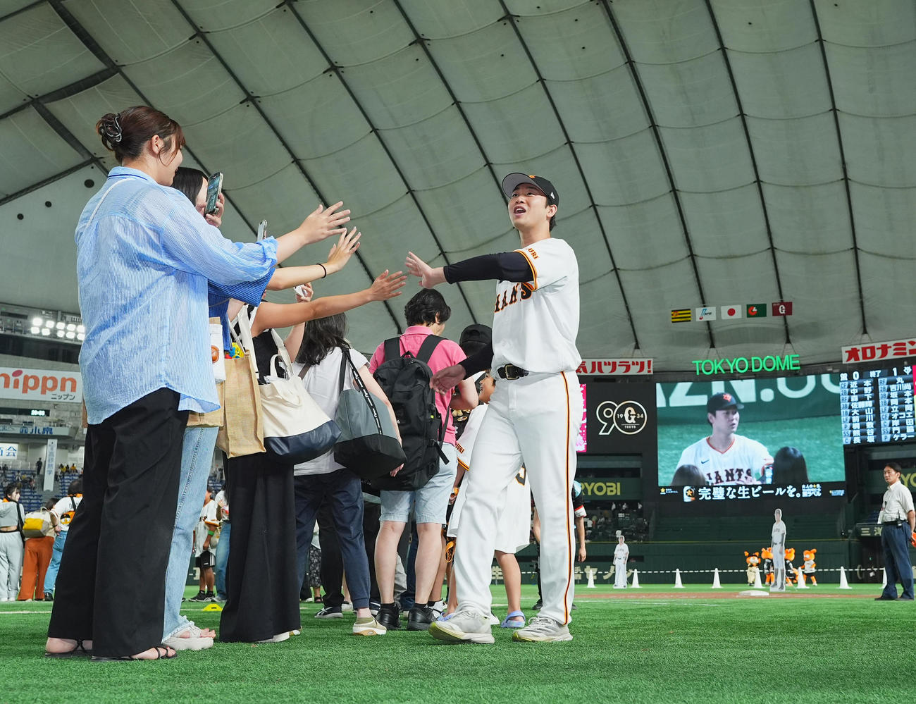 巨人対阪神　阪神に勝利し、ファンとタッチをする巨人山崎伊（右）（撮影・菅敏）