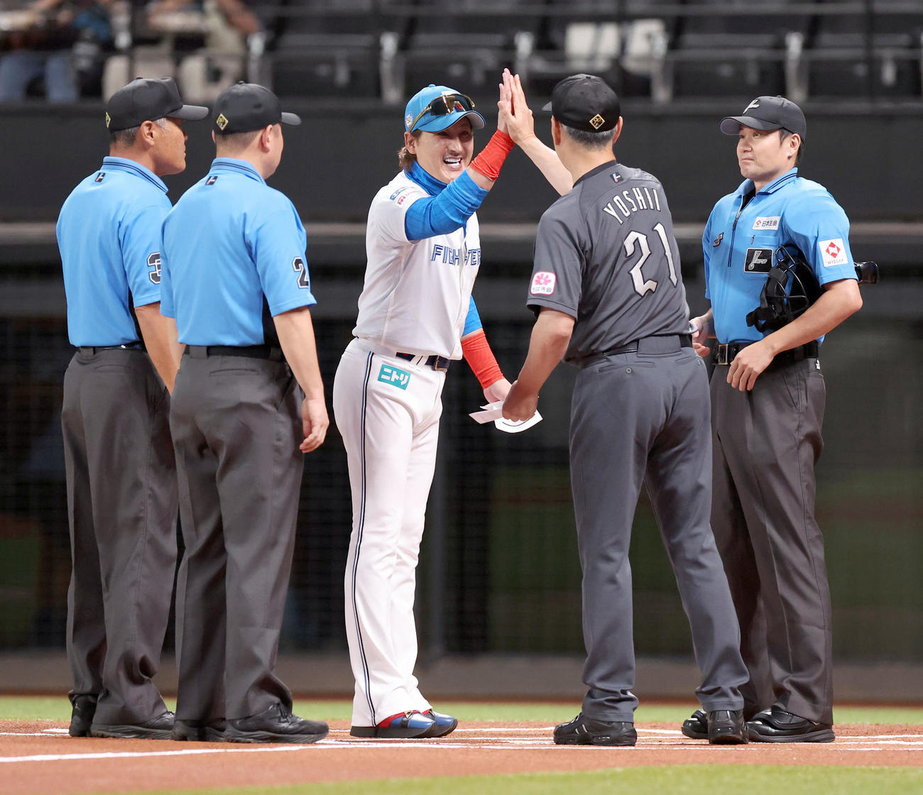 日本ハム対ロッテ　メンバー表を交換しハイタッチをする日本ハム新庄監督（中央）とロッテ吉井監督（撮影・佐藤翔太）