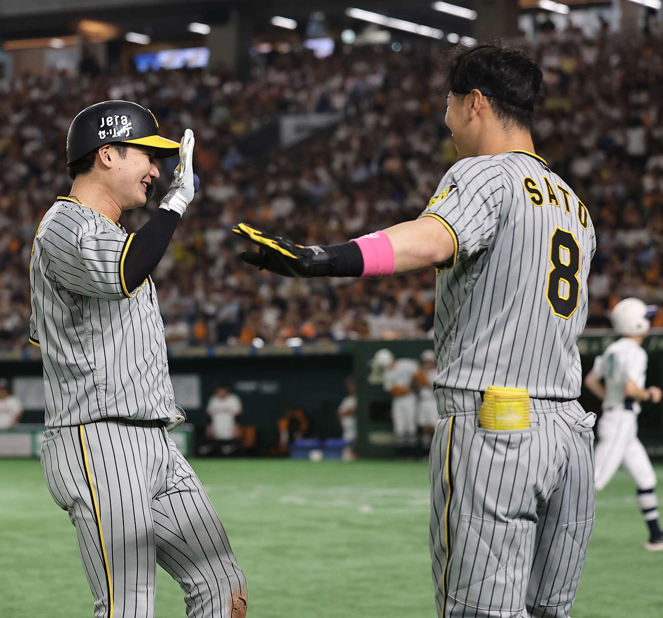 巨人対阪神　7回表阪神1死満塁、勝ち越し3点適時二塁打を放った渡辺（左）はベンチ前で出迎えた佐藤輝とハイタッチする（撮影・上田博志）