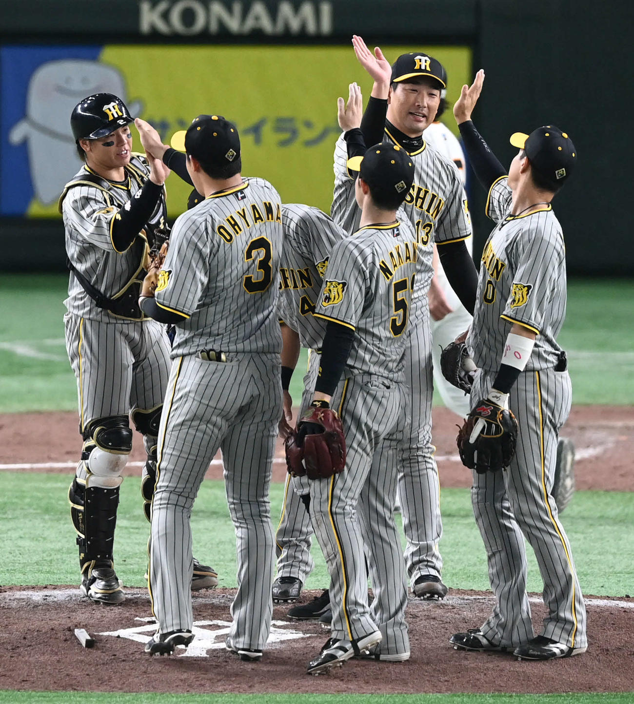 巨人対阪神　18セーブ目を挙げた阪神岩崎（右から2人目）はチームメートとタッチを交わす（撮影・山崎安昭）
