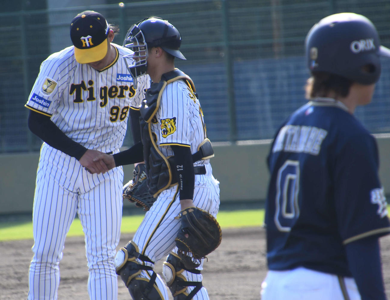 ウエスタン・リーグのオリックス戦で試合を締めた阪神佐藤蓮（左）と握手する捕手坂本