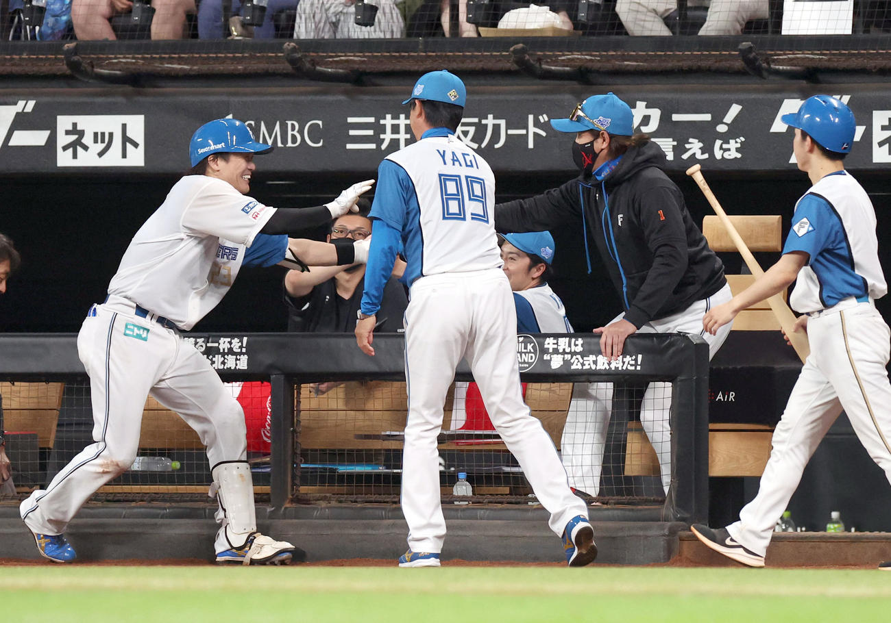 日本ハム対ロッテ　2回裏日本ハム無死二、三塁、スクイズを決めた伏見（左）を出迎える新庄監督（撮影・佐藤翔太）