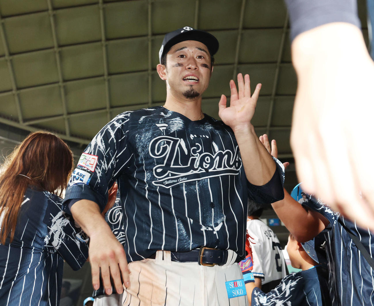 西武対ソフトバンク　ファンと勝利のタッチを交わす西武外崎（撮影・宮地輝）