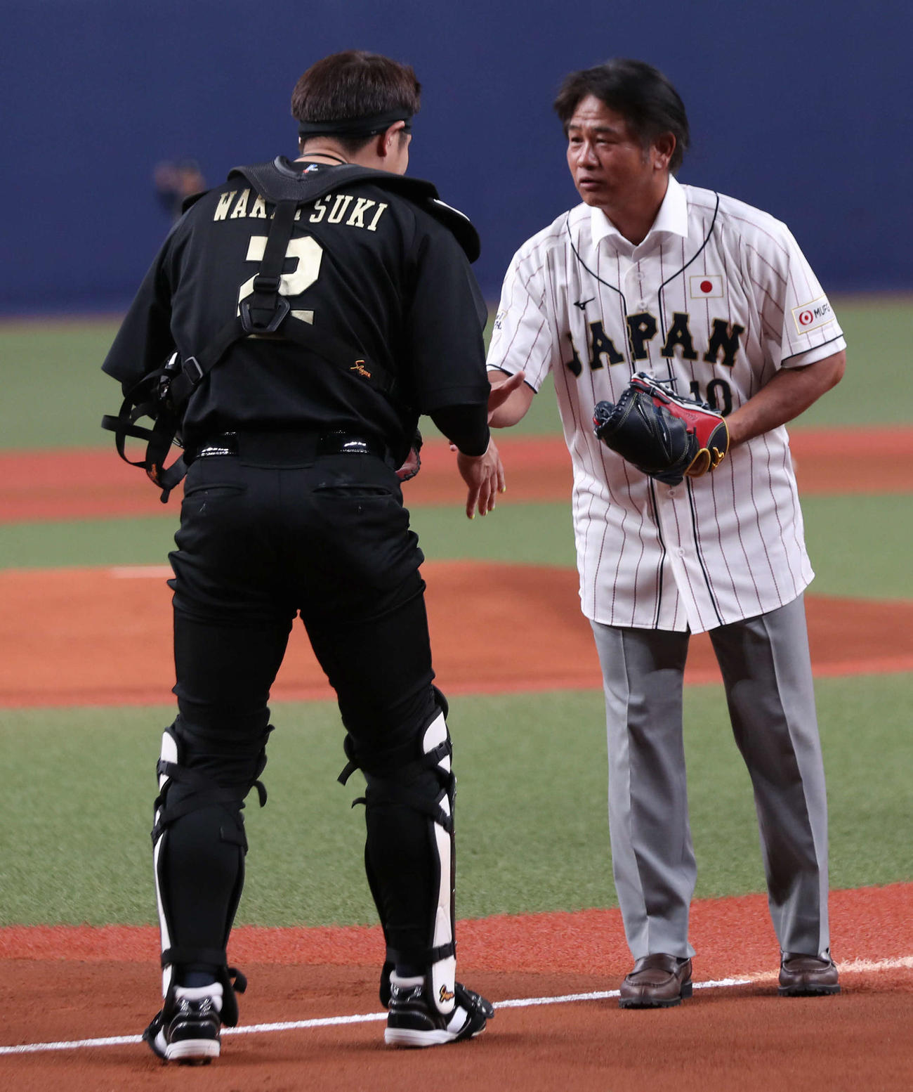 オリックス対楽天　侍ジャパンデーのため始球式に登場したオリックスOBの谷佳知氏は若月と握手をかわす（撮影・西尾就之）