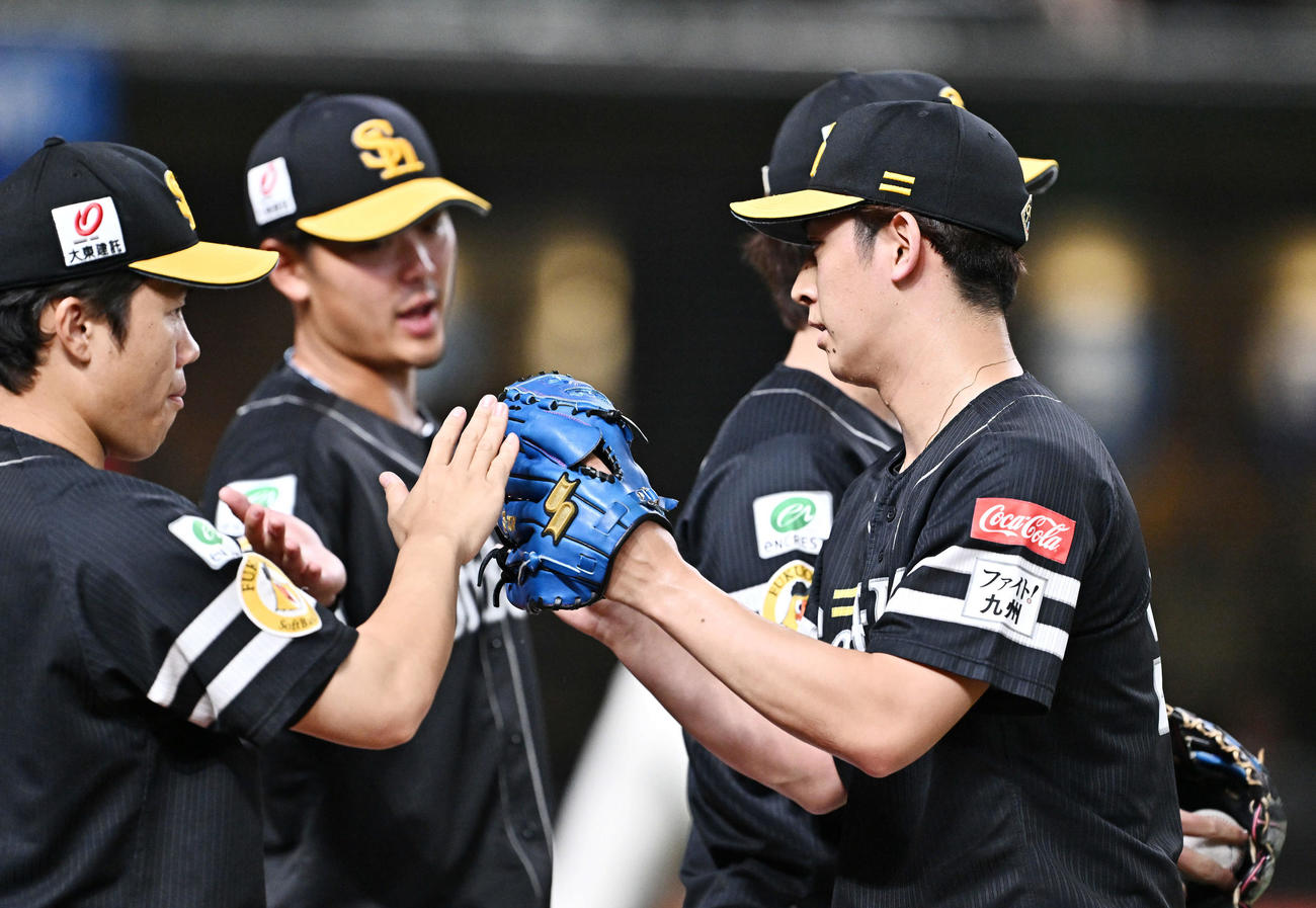 西武対ソフトバンク　4回裏を投げ終えたソフトバンク2番手の大山（右手前）はチームメートとタッチをかわす（撮影・滝沢徹郎）
