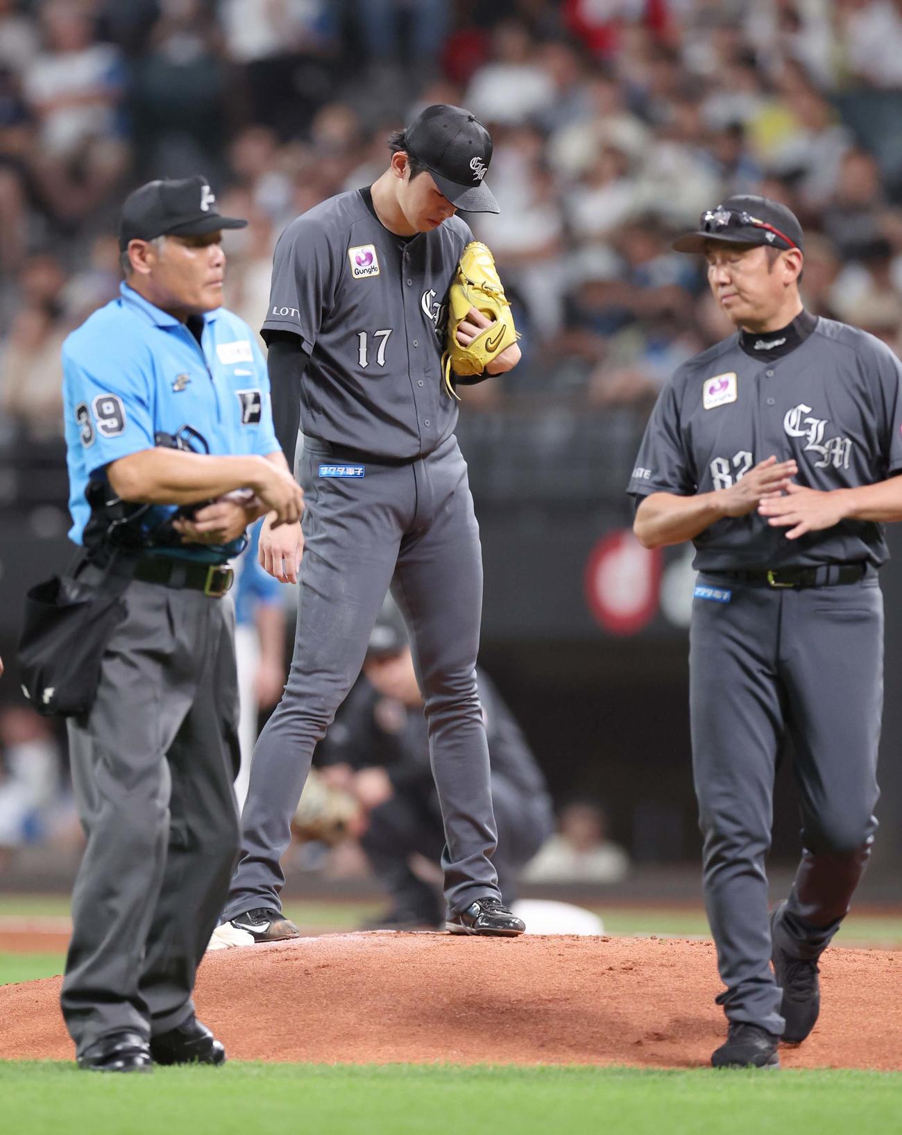 日本ハム対ロッテ　2回裏日本ハム1死、浅間の打球が足に当たり治療後、マウンドに戻るも小野投手コーチ（右）が×印を出し降板する佐々木（撮影・黒川智章）