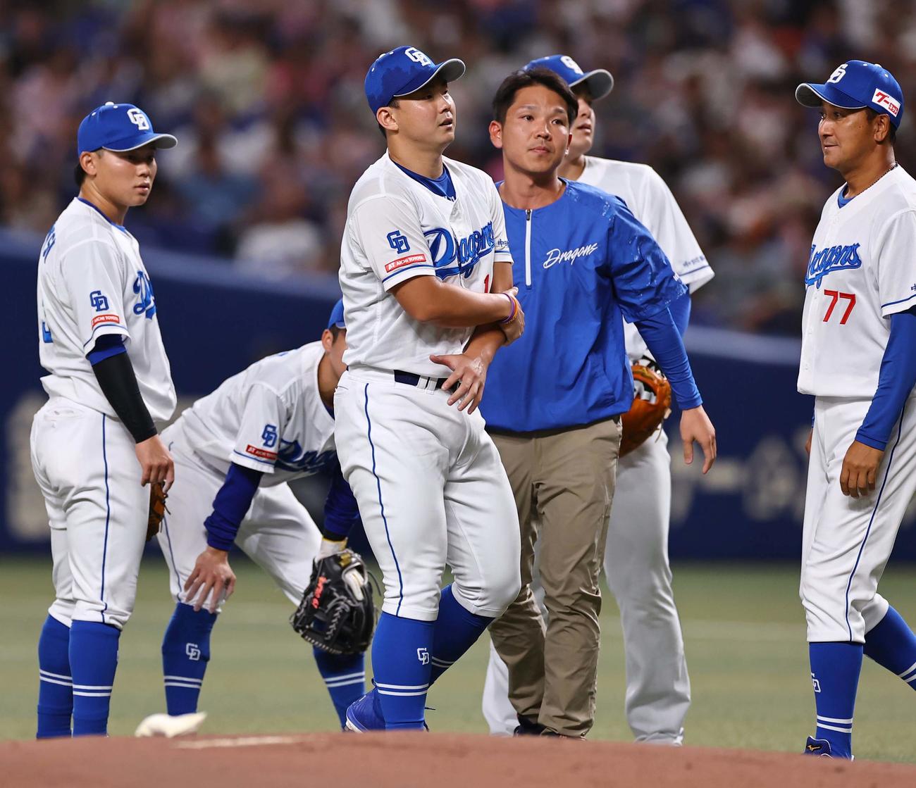 中日対阪神　1回表阪神無死、近本の打球を左ひじに当てた小笠原（中央）はベンチに下がって治療する（撮影・上田博志）