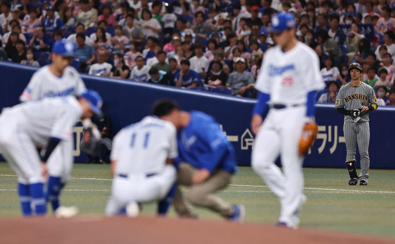 中日対阪神　1回表阪神無死、打球の当たった小笠原を心配する近本（撮影・上田博志）