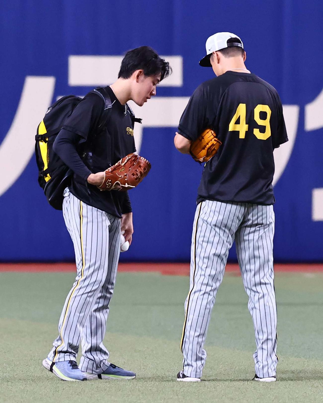 中日対阪神　大竹（右）は富田に何かを見せる。指？（撮影・上田博志）