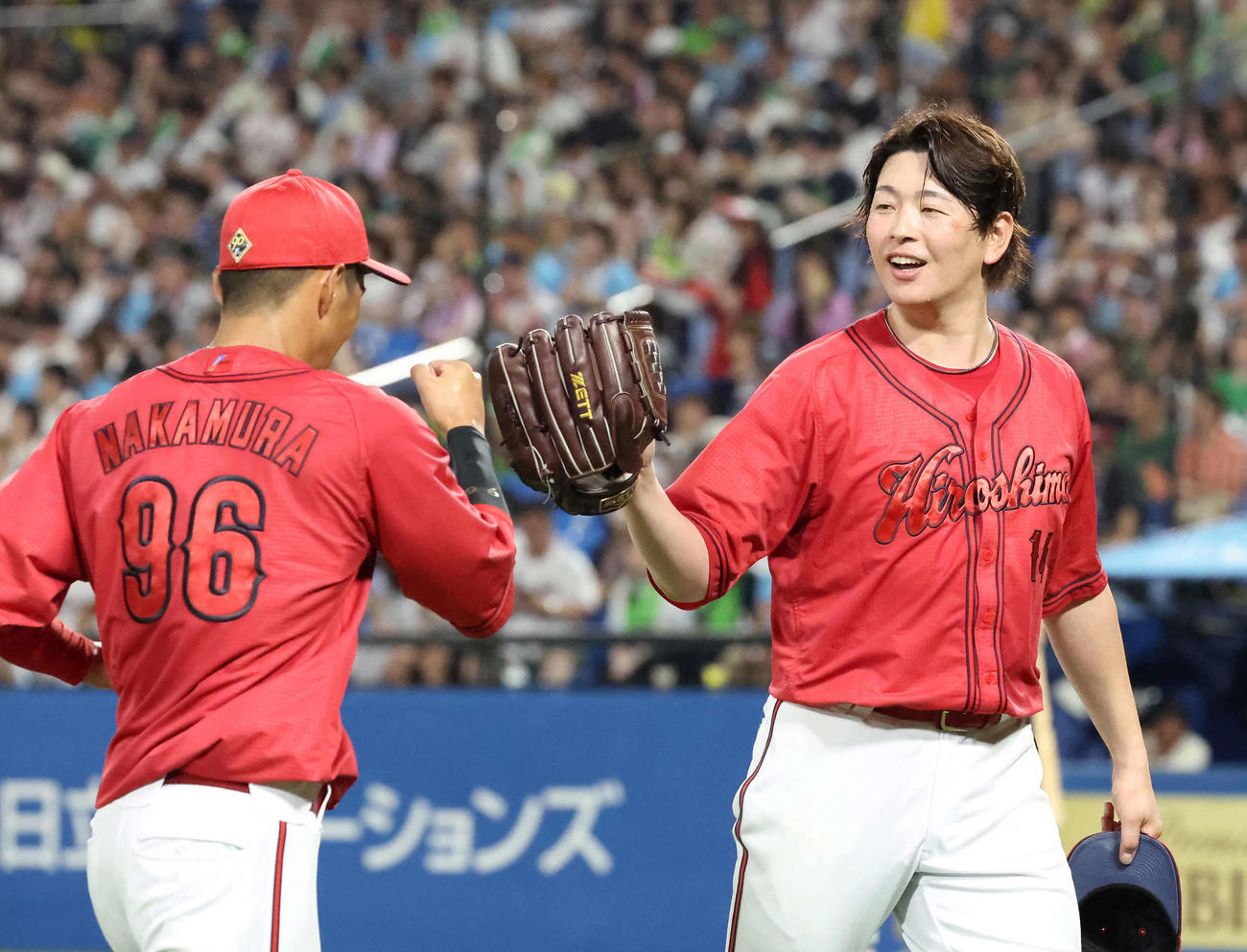 ヤクルト対広島　5回、好守の左翼手中村奨とタッチを交わす大瀬良（撮影・丹羽敏通）