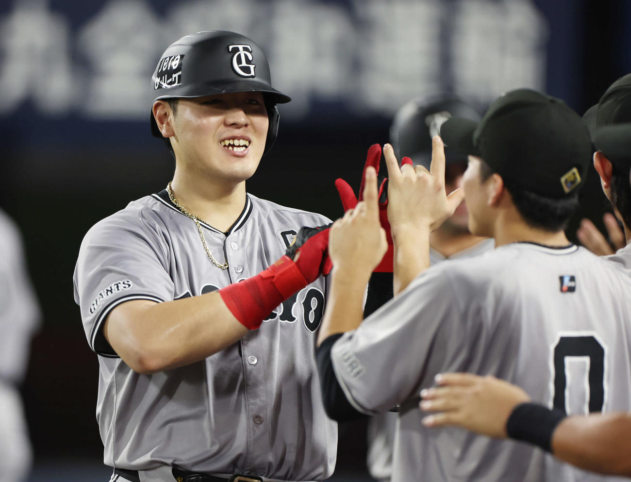 DeNA対巨人　4回表巨人無死一塁、右越え2点本塁打を放った岡本和はチームメートと笑顔でタッチを交わす（撮影・宮地輝）