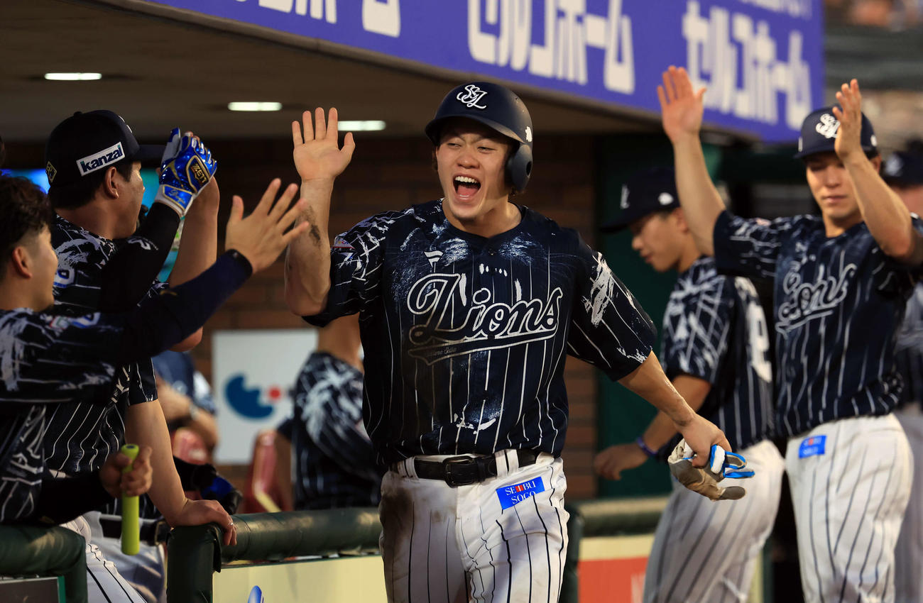 楽天対西武　2回表西武無死満塁、源田の右適時打で生還した奥村（中央）は笑顔でナインとハイタッチ（撮影・浅見桂子）