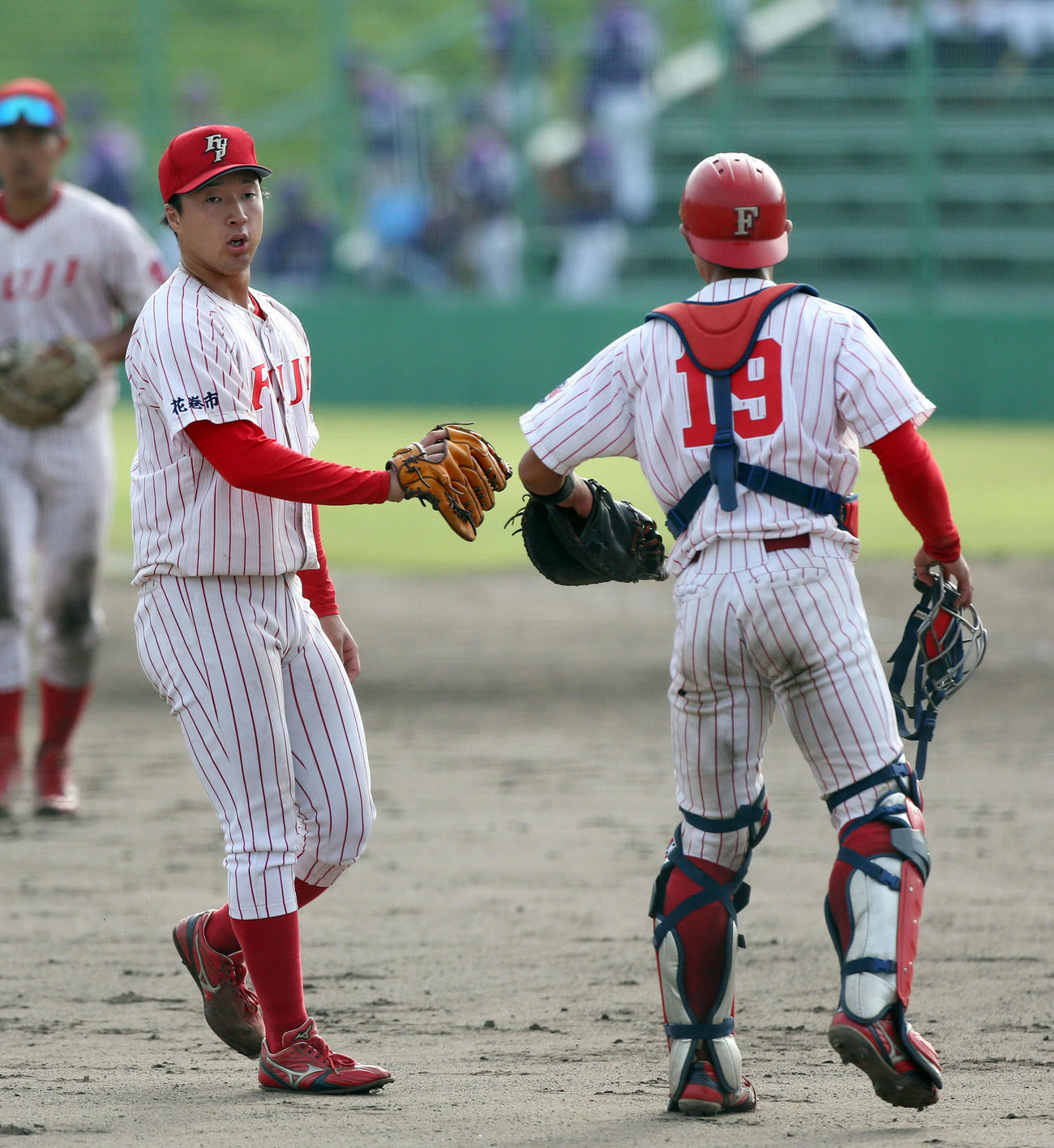 富士大対青森中央学院大　完投した富士大・佐藤（左）は坂本とグラブタッチをかわす（撮影・木村有優）
