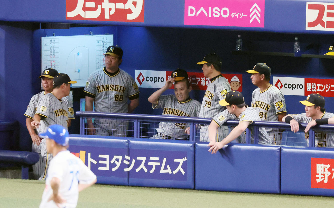 中日対阪神　4回裏中日無死満塁、2番手で登板した伊藤将が安打と四球で満塁とし、ベンチで帽子を取りながらコーチ陣と話す岡田監督（撮影・加藤哉）