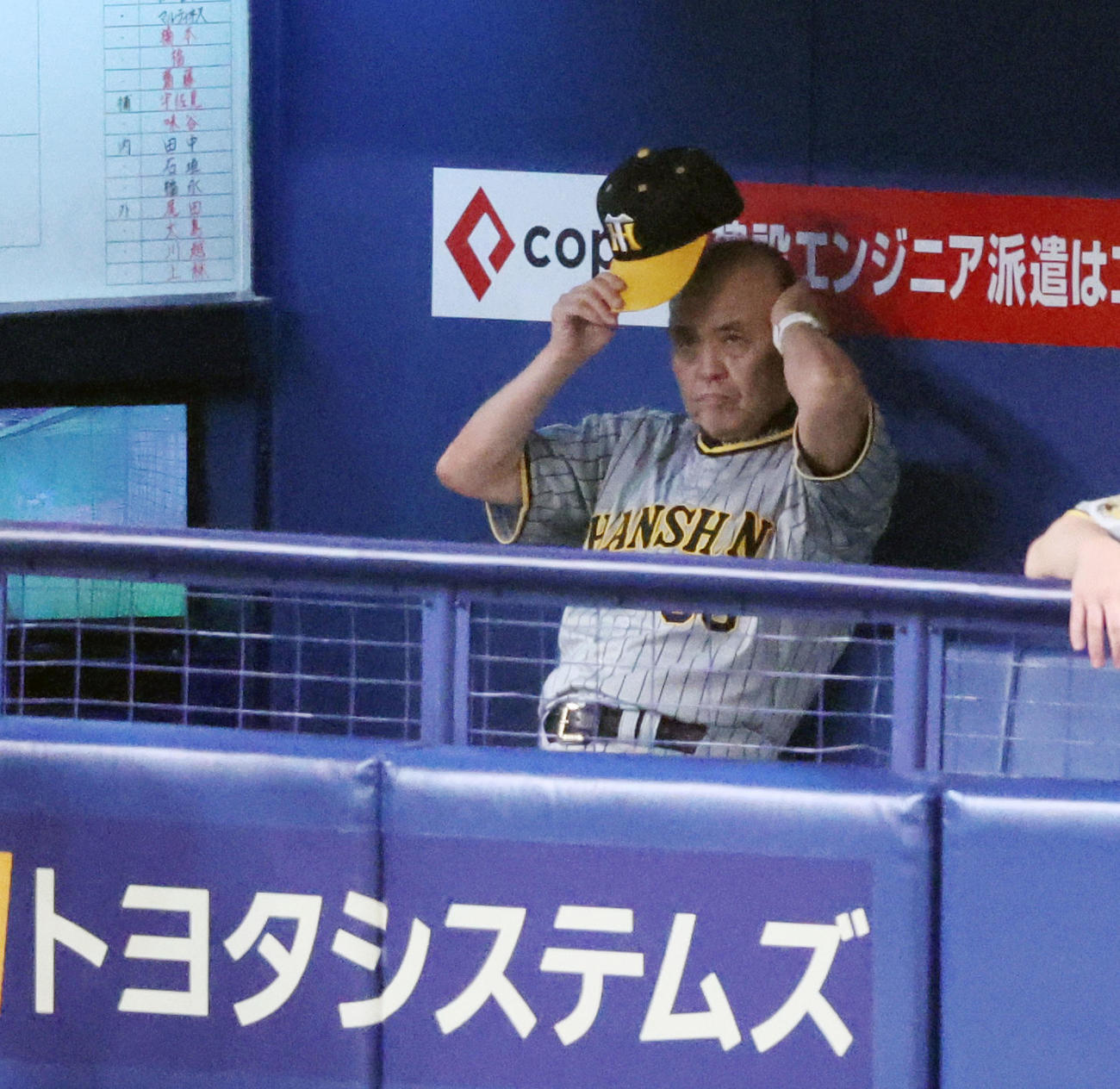 中日対阪神　2回表を終えベンチで帽子を取る岡田監督（撮影・加藤哉）