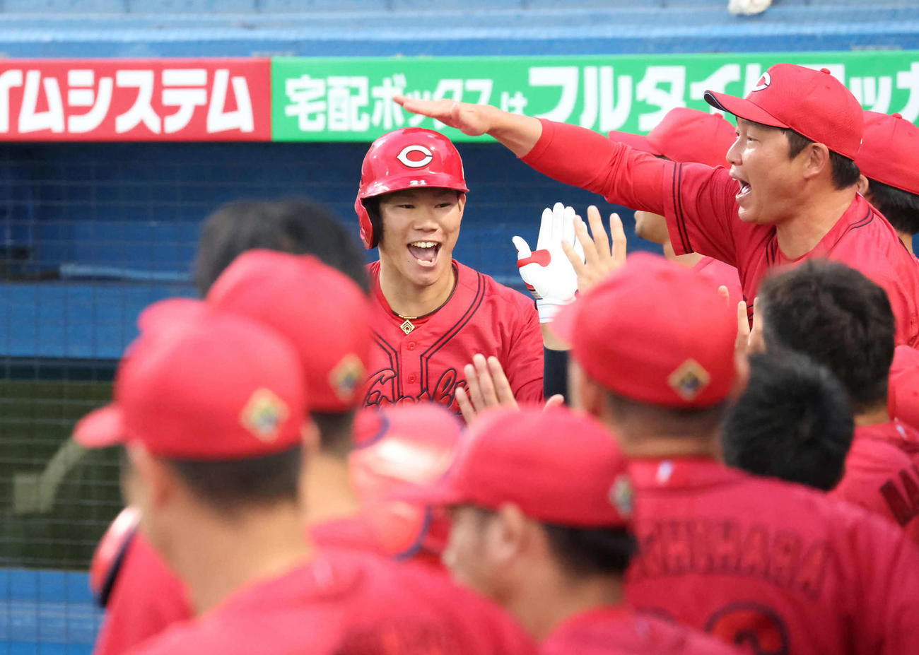 ヤクルト対広島　1回表広島2死二、三塁、坂倉は左越えに先制の3点本塁打を放ち新井監督の祝福を受ける（撮影・丹羽敏通）