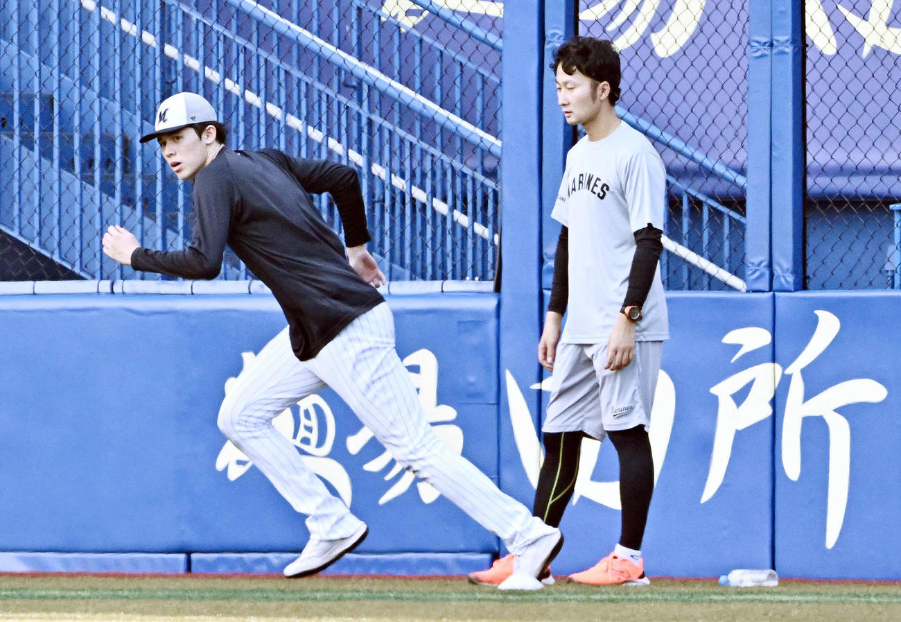 ロッテ対日本ハム　試合前練習で調整するロッテ佐々木（左）（撮影・滝沢徹郎）