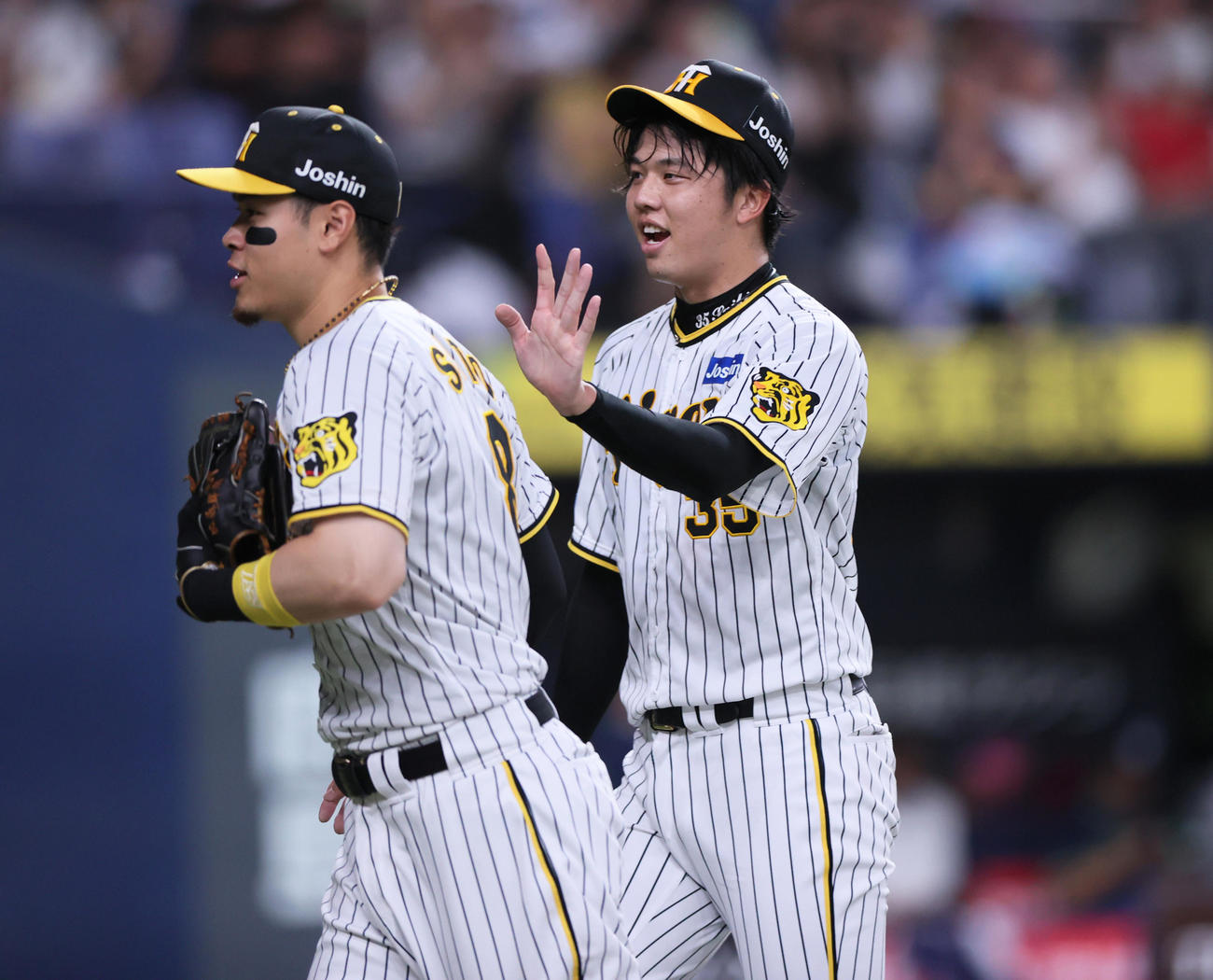 阪神対ヤクルト　7回表ヤクルト2死一、二塁、才木は岩田を左飛に仕留め笑顔でベンチへ引き揚げる。手前は佐藤輝（撮影・上山淳一）