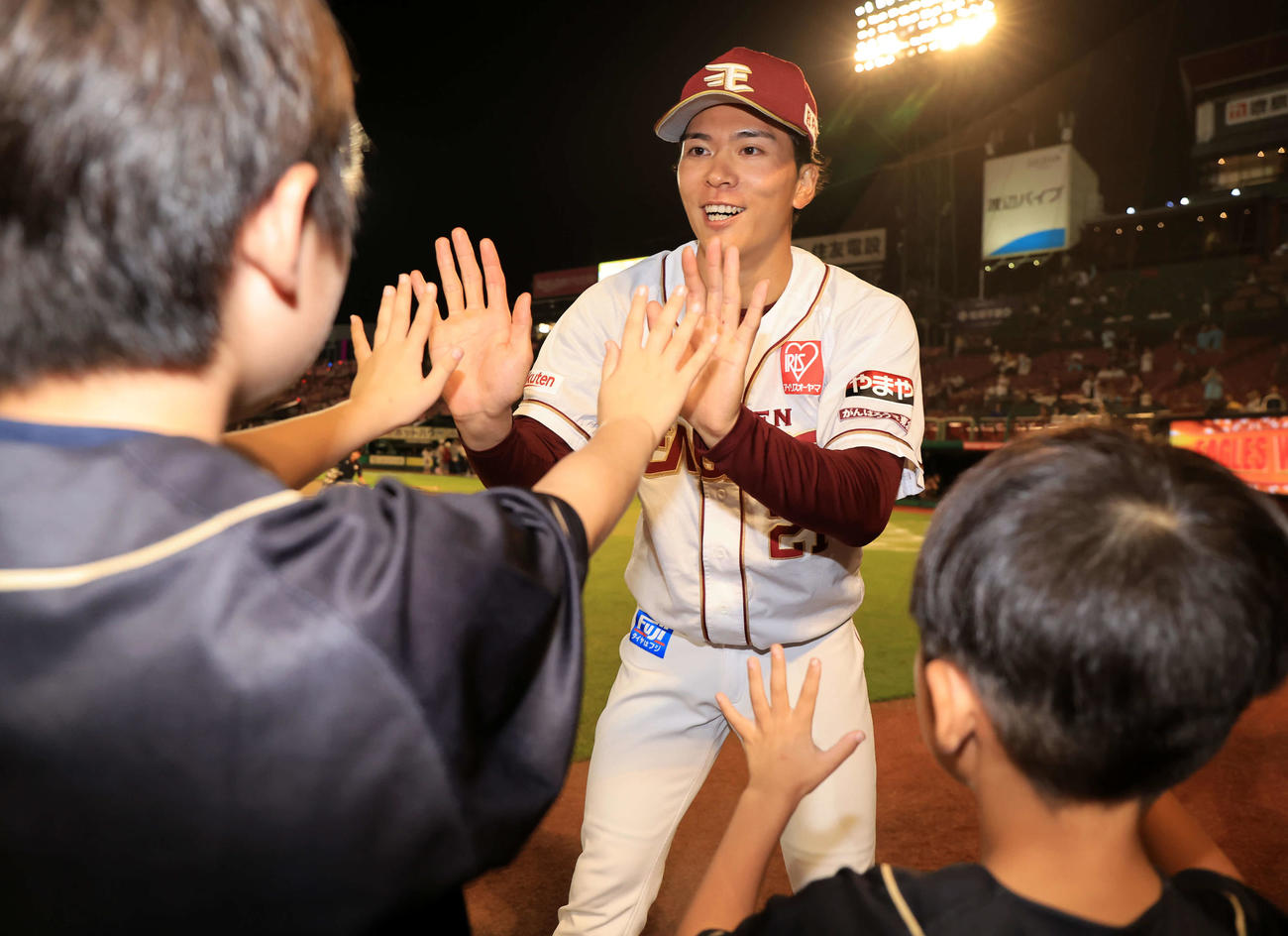 楽天対ソフトバンク　9勝目の楽天早川（奥）は少年ファンと笑顔でハイタッチ（撮影・浅見桂子）