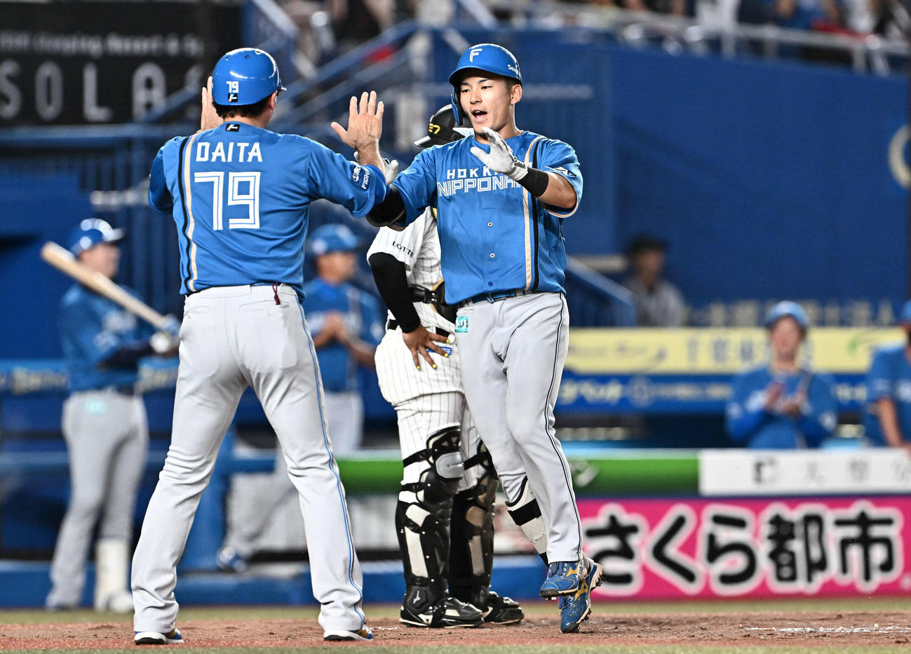 ロッテ対日本ハム　3回表日本ハム無死、ソロ本塁打を放った水野（右）は代田コーチとタッチをかわす（撮影・滝沢徹郎）
