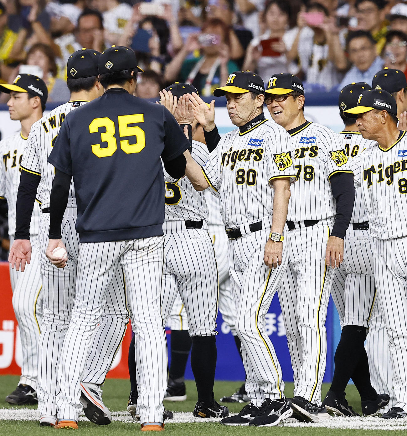 阪神対ヤクルト　勝利を飾り才木らとタッチを交わす阪神岡田監督（中央）（撮影・藤尾明華）