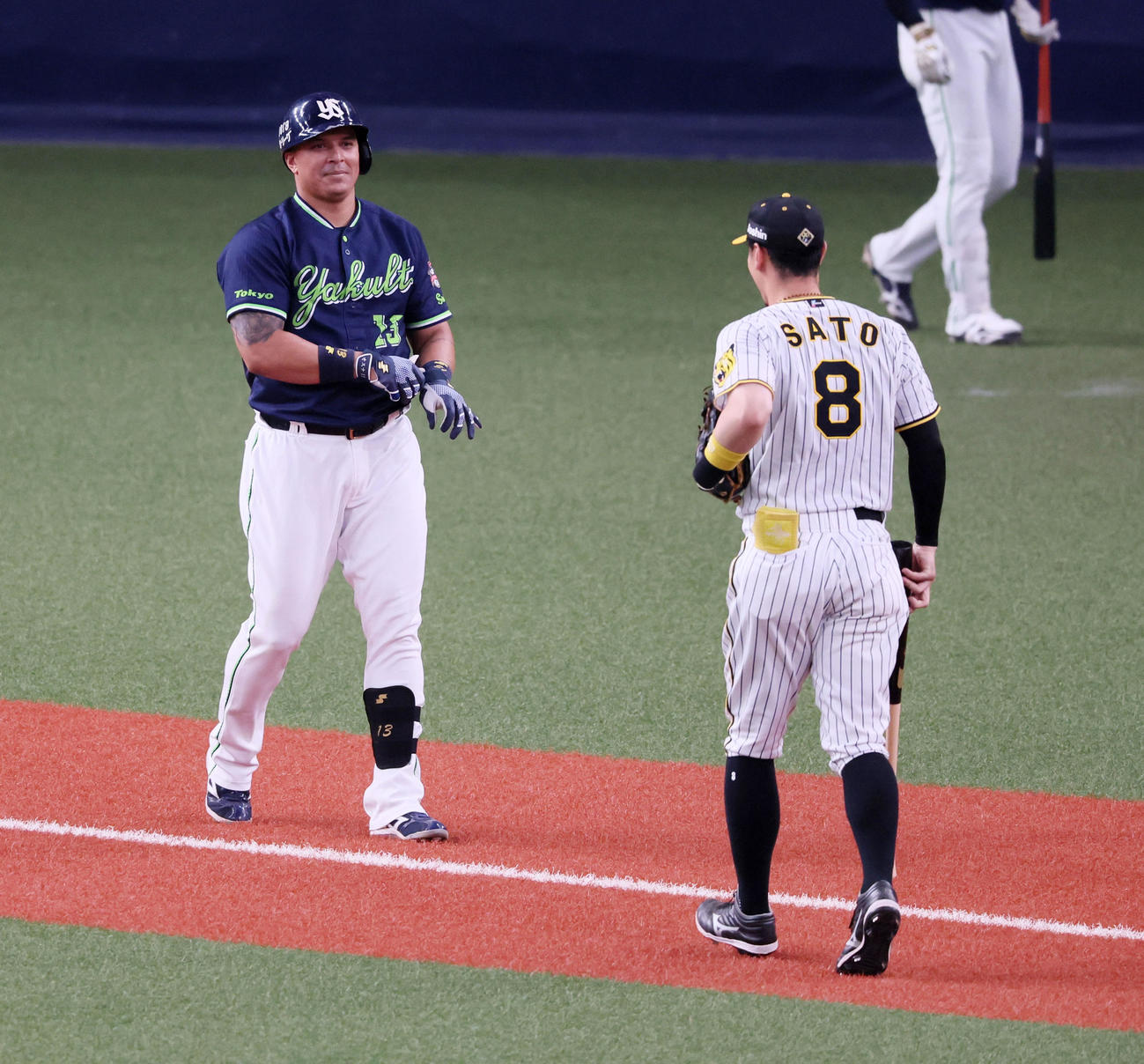 阪神対ヤクルト　6回表ヤクルト1死三塁、オスナ（左）が空振りで飛ばしたバットを返す佐藤輝（撮影・加藤哉）